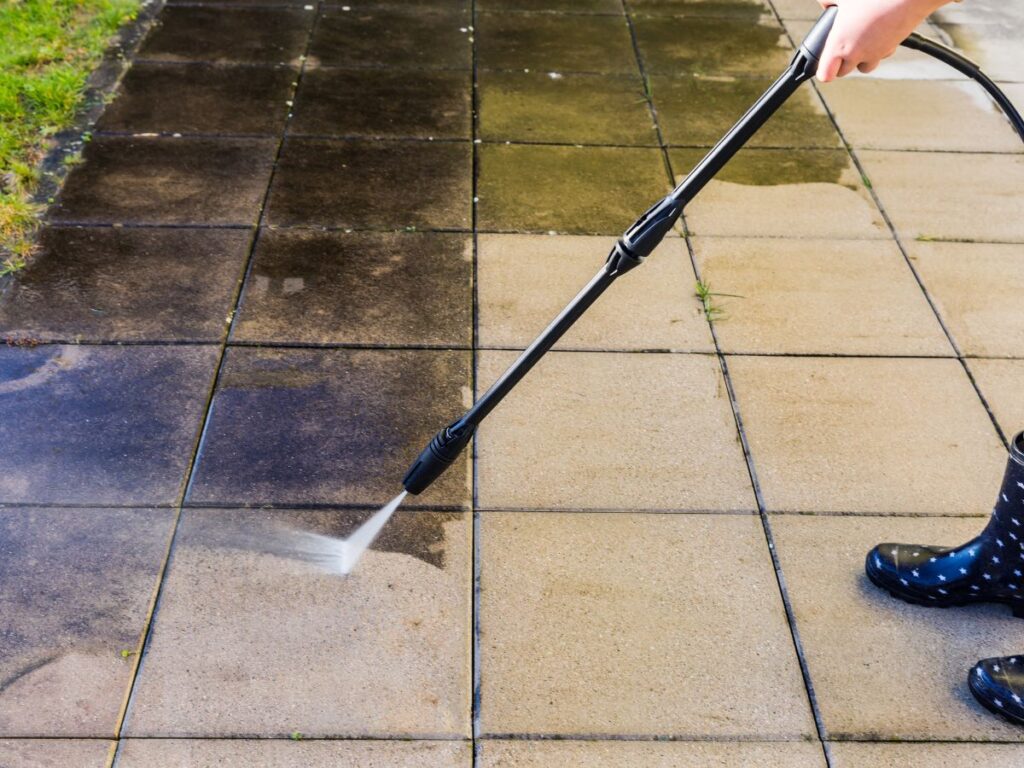 Professional Pressure Washing in Bridgewater, MA: What Makes South Shore Soft Wash Different 2 Cleaning dirty patio tiles with pressure washer wand.
