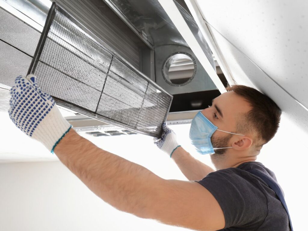 HVAC Duct Cleaning vs Air Duct Cleaning: What's the Difference and Which Does Your Home Need? 1 Technician removing HVAC vent cover for cleaning.