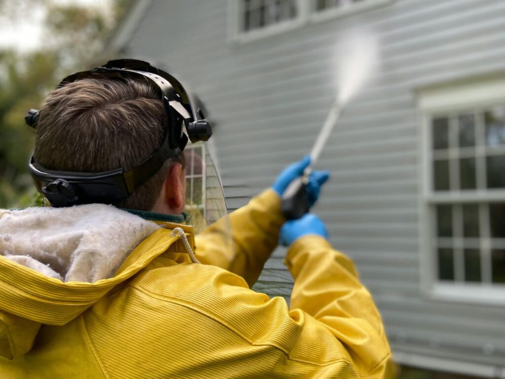 Pressure Washing in Bridgewater, MA: Why Spring Is the Best Time to Clean Your South Shore Home 1 Person pressure washing house siding outdoors.