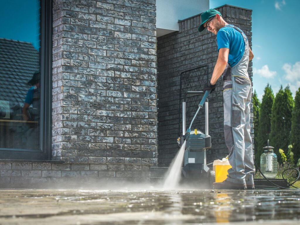 Pressure Washing in Bridgewater, MA: Why Spring Is the Best Time to Clean Your South Shore Home 2 Worker pressure washing patio outside brick home.